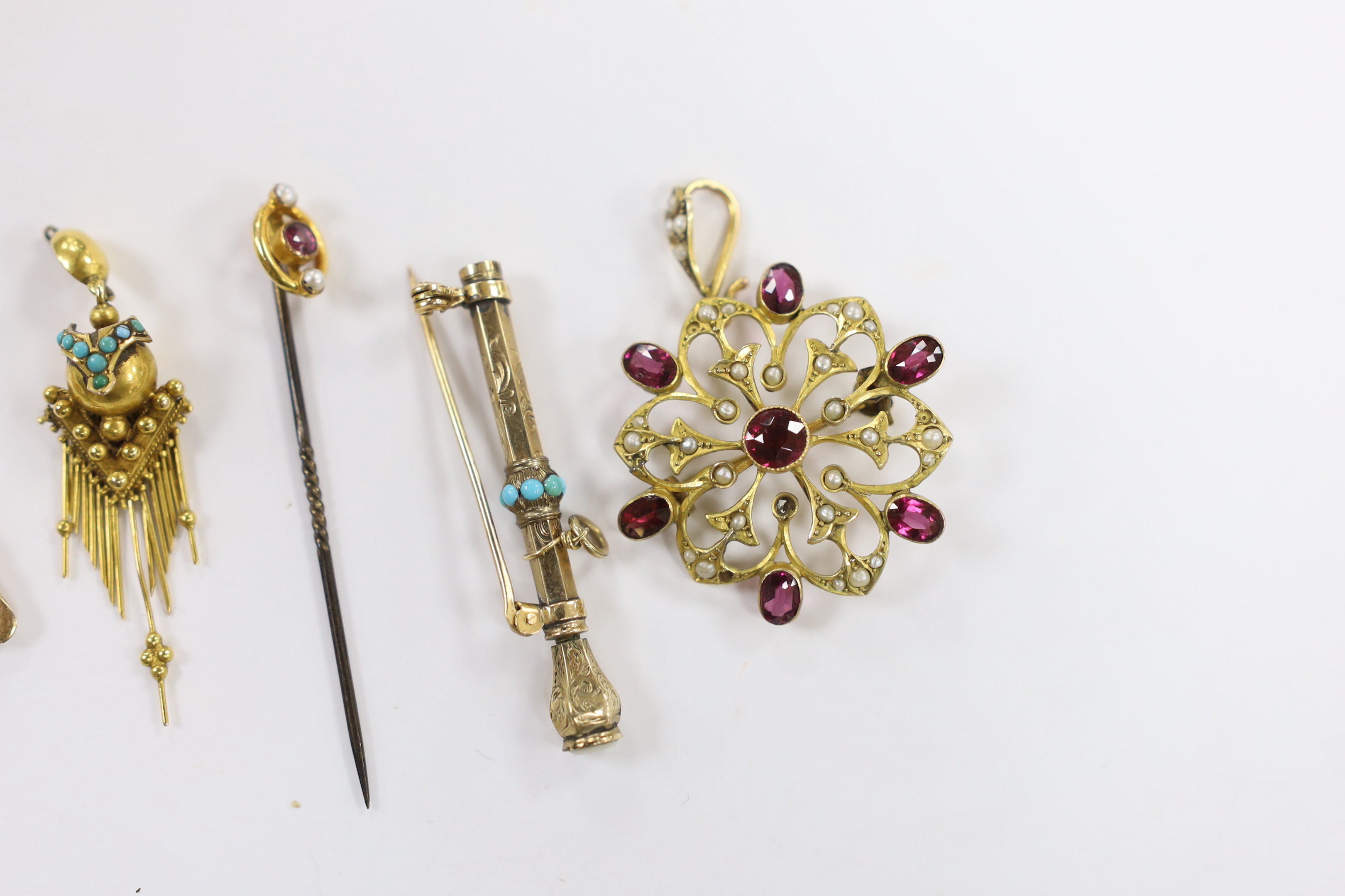 An early 20th century 9ct, garnet and seed pearl cluster set pendant, diameter 32mm, a yellow metal and gem set stylised pendant, a Victorian yellow metal and turquoise set tassel earring, a 9ct and gem set stick pin and